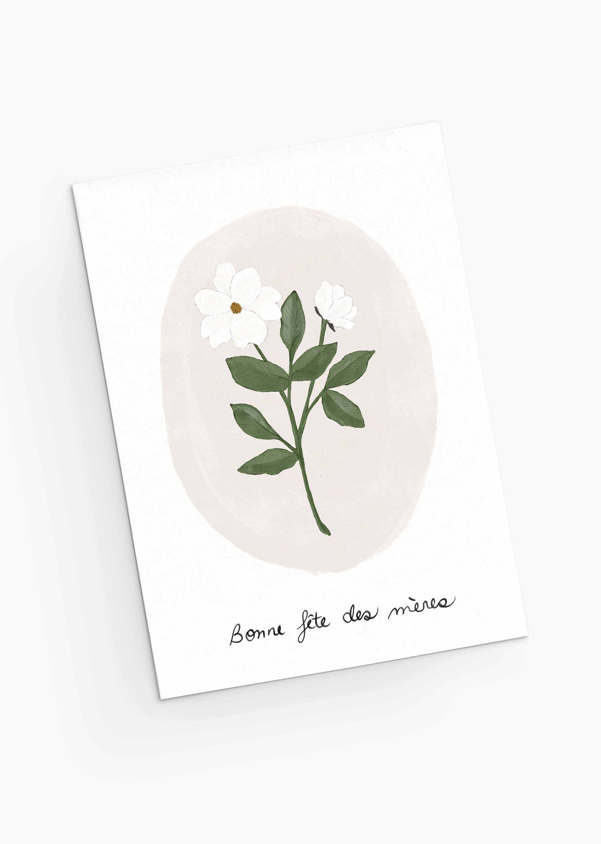 The White Flower Mother's Day Greeting Card from Mimi & August is crafted from recycled paper, featuring a white flower and green leaves illustration with the French greeting "Bonne fête des mères," conveying the delicate charm of pastel blooms.