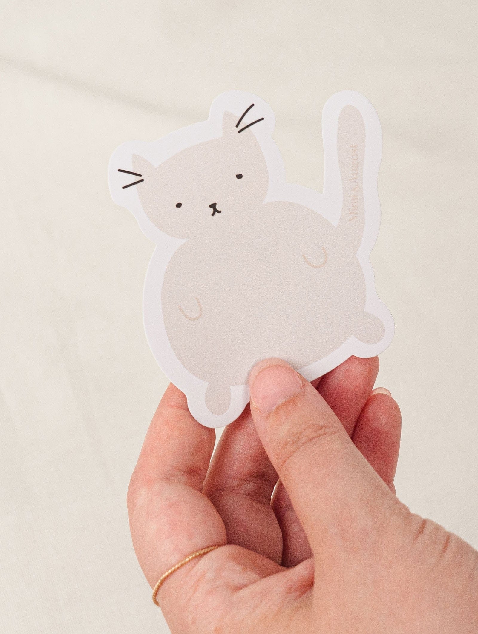 Grey cat vinyl sticker in a hand