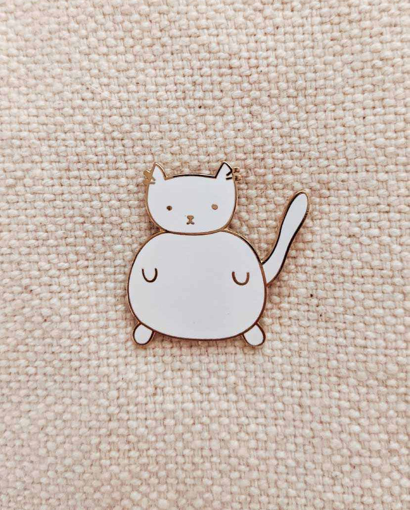 Charlotte Enamel Pin small white cat enamel pin with gold tone brass on fabric background