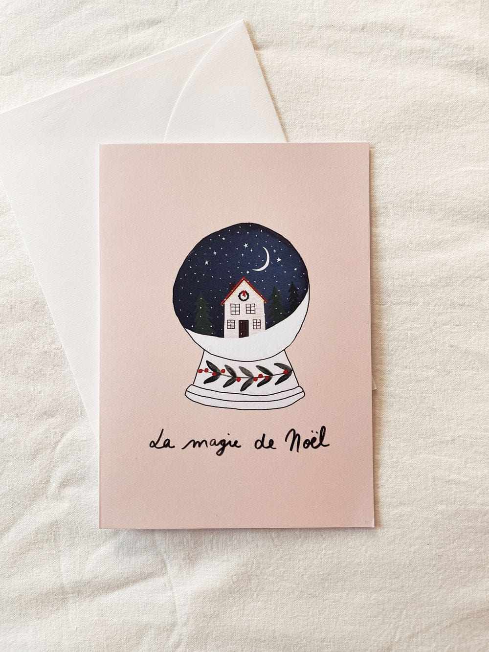 La Magie de Noël greeting card with a snow globe illustration, blank inside, recycled paper, matte cardstock, and white envelope.