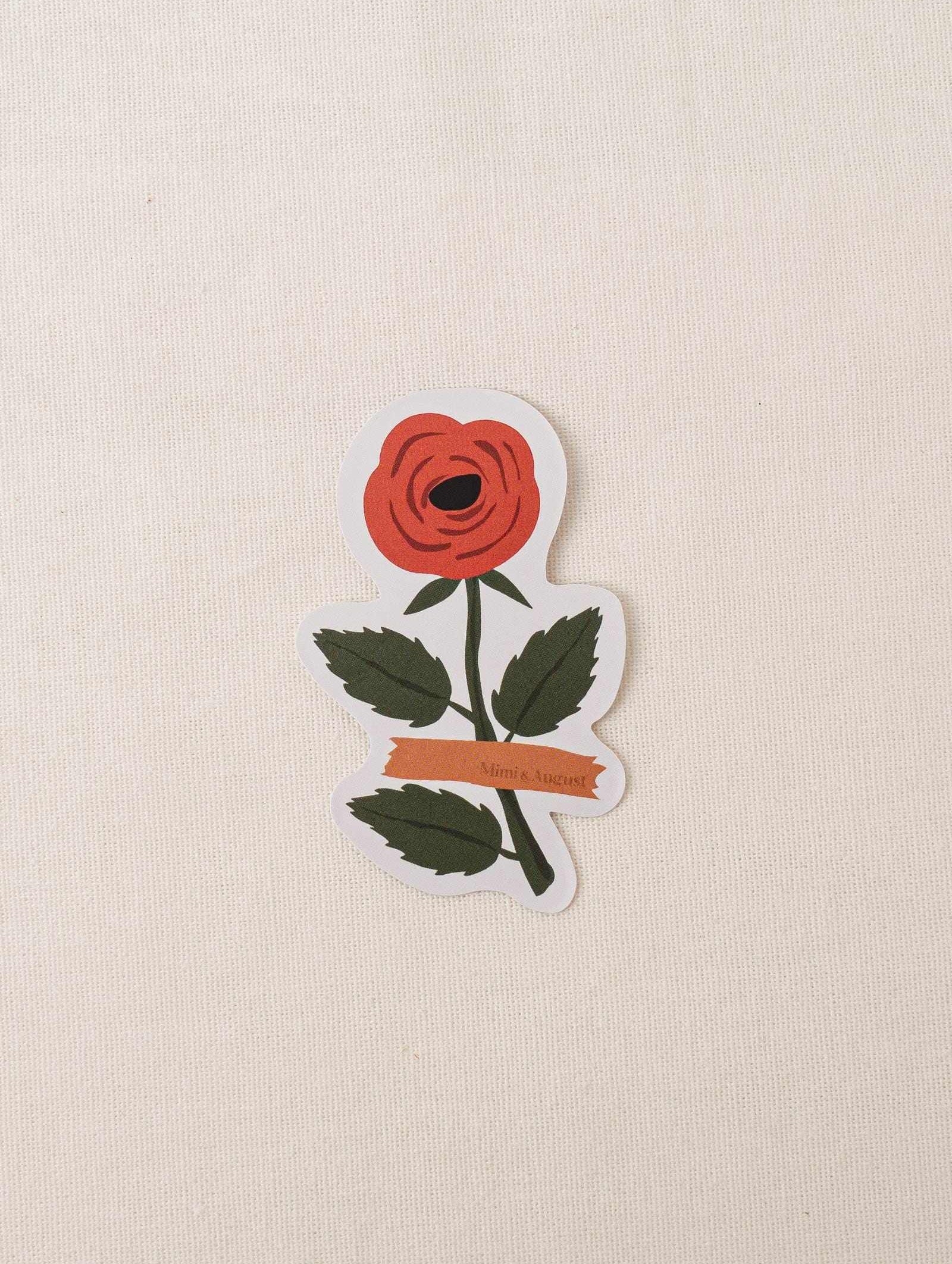 Red rose vinyl sticker with white border on beige background