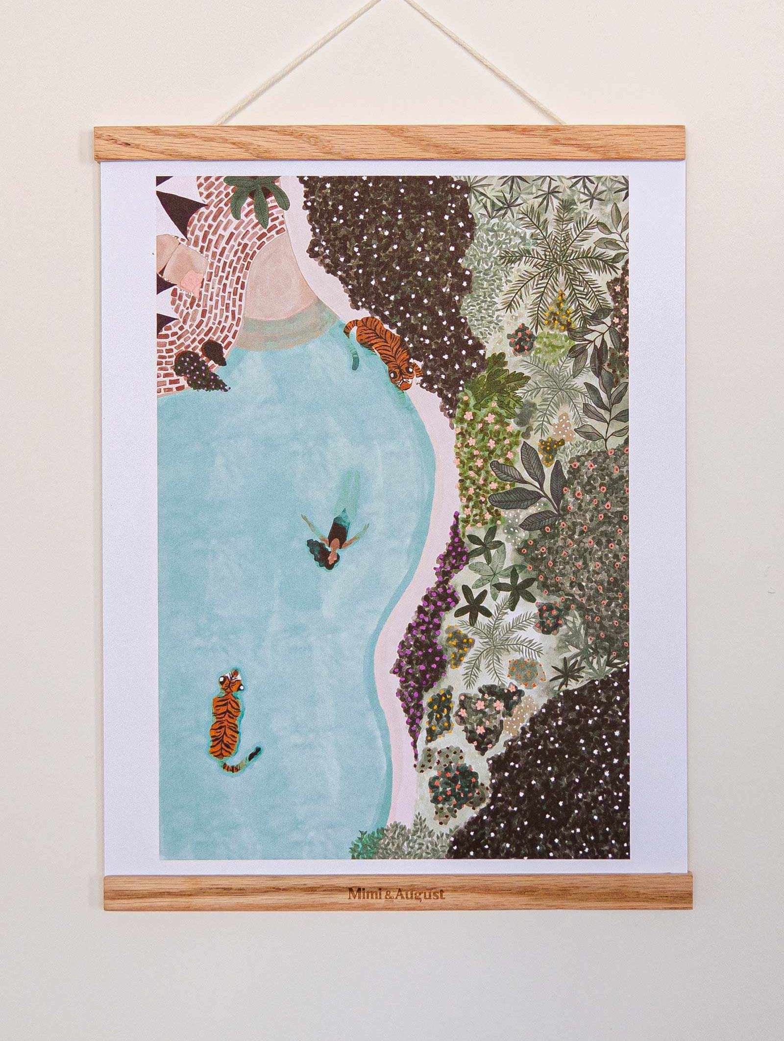 Swimming with Tigers Art Print hanging with wooden frame showing tiger swimming in blue water surrounded by lush greenery illustration
