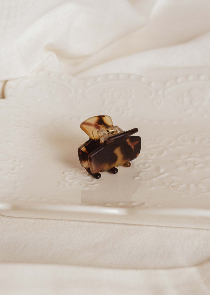 Tortoise Matte mini hair clip in a decorative white plate