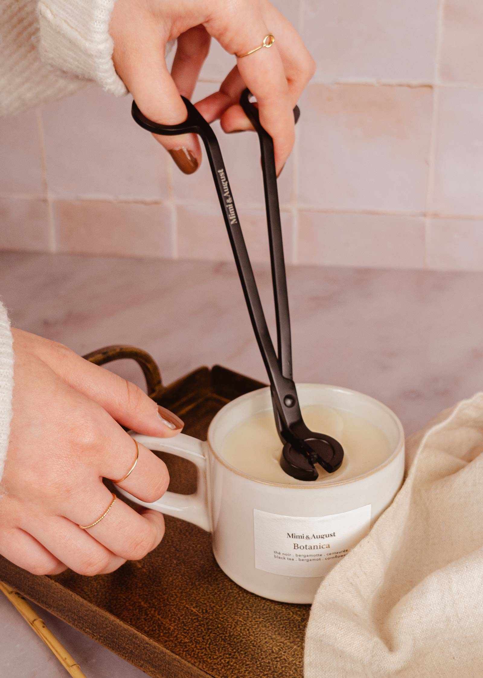 cutting the wick of a candle with matte black trimmer