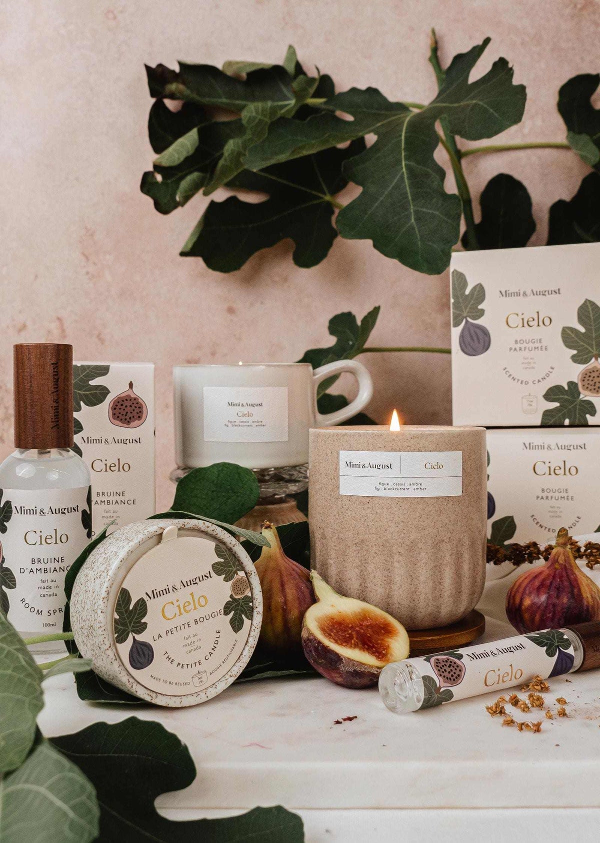 Fig candle in reusable ceramic cup with fig fruits and green leaves around on a marble surface