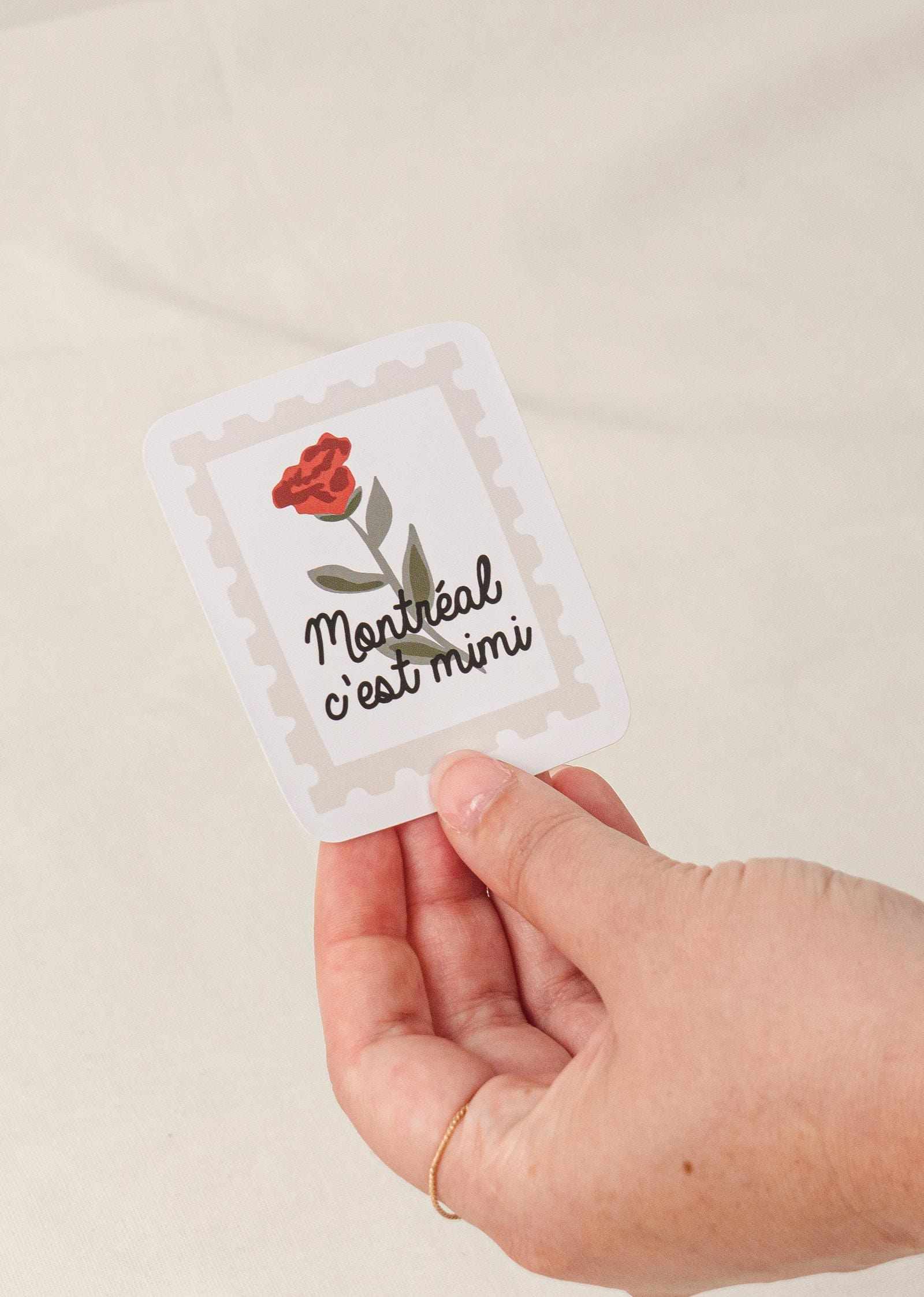 Flower Stamp - Vinyl Sticker with red flower and Montreal c'est mimi text held in hand with white border and matte finish