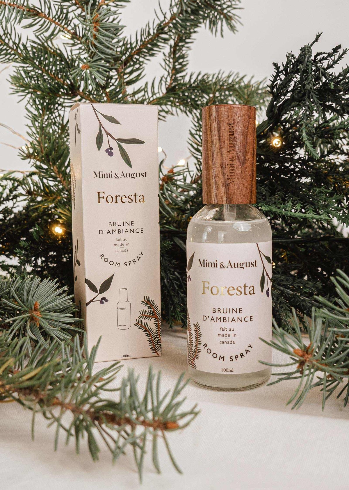 Forest room spray Foresta by Mimi & August with fir needle and cedarwood scent surrounded by evergreen branches