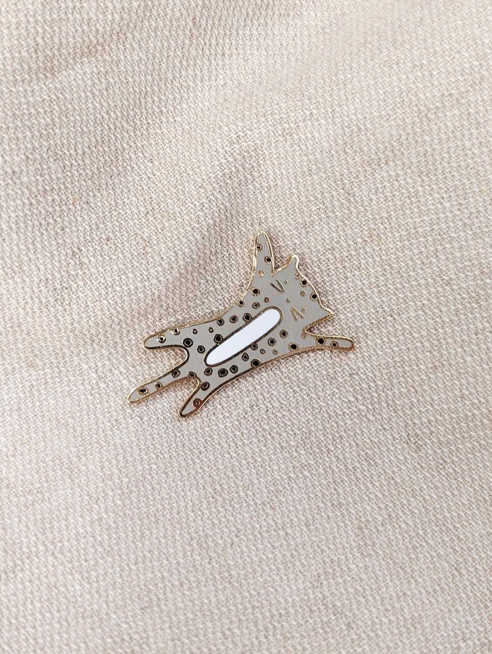 Geppetto enamel pin gold tone brass kitten design on fabric background