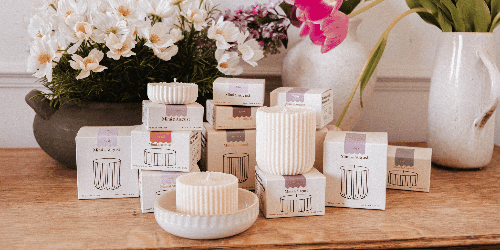 candle refills in cream packaging with ribbed ivory wax inserts displayed beside white flowers and ceramics