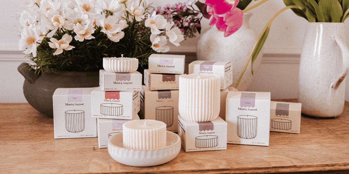 candle refills in cream packaging with ribbed ivory wax inserts displayed beside white flowers and ceramics