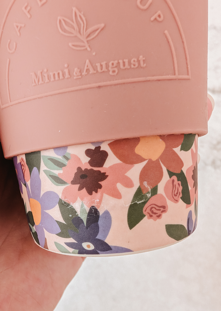 Une tasse rose Defect Café Yo Cup de Mimi & August, ornée d'un motif floral.