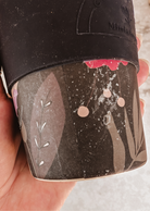 A person holding a Mimi & August Defect Café Yo Cup with flowers on it.