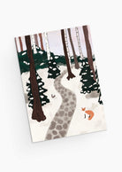 A charming scene titled "A Forest Full of Winter Magic" from Mimi & August illustrates a snowy woodland with a stone path weaving between majestic trees, where a curious fox encounters a timid rabbit. This enchanting imagery beautifully embodies the wonder found on the recycled paper Christmas greeting card.