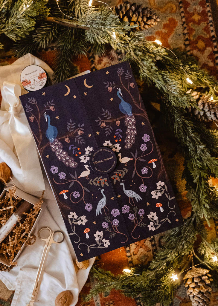 A Advent Calendar - The Twelve Enchanted Days filled with ornaments and decorations, including scented candles, on a festive rug.