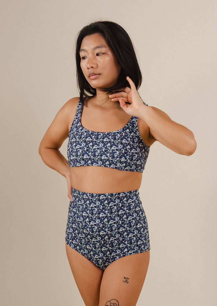 A woman in a blue floral bikini kit by mimi and august