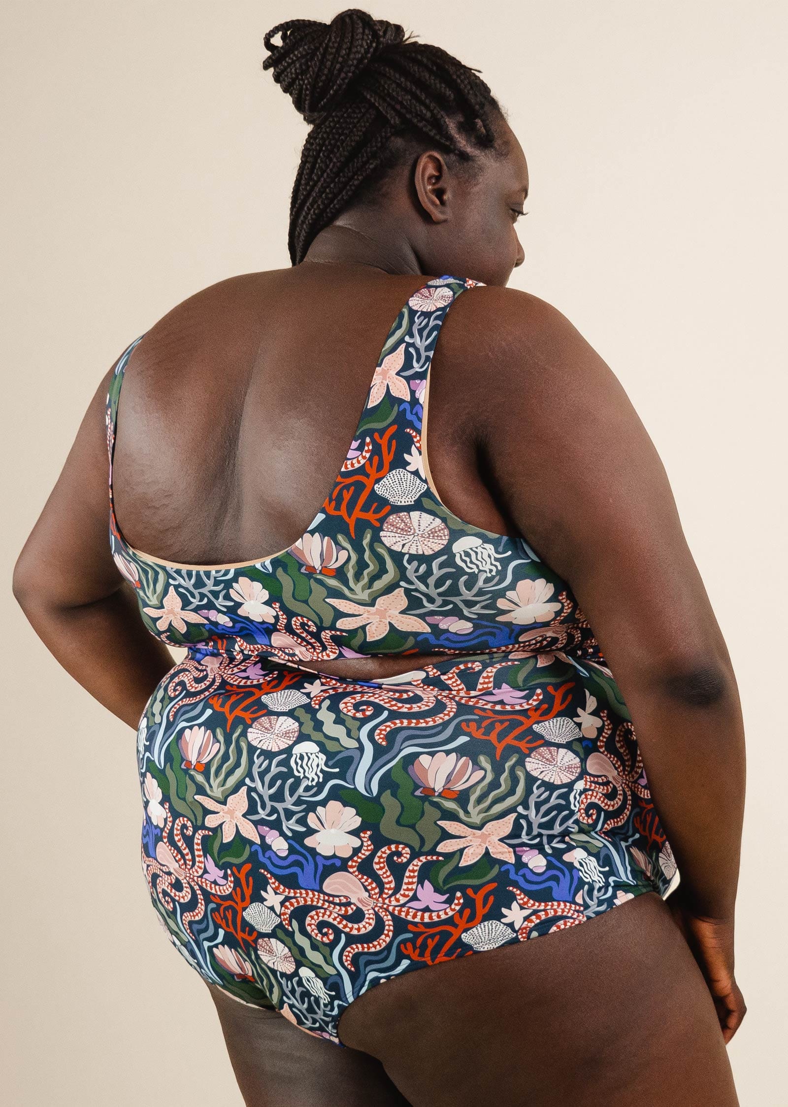 A plus size woman in Oceana Extra High Waist Bikini Bottom with a matching floral print top.