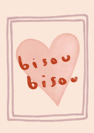 The Bisou Bisou Art Print by Mimi & August showcases a minimalist pink heart with "bisou bisou" inside, encased in a rectangular border on a beige background and is crafted on recycled paper.