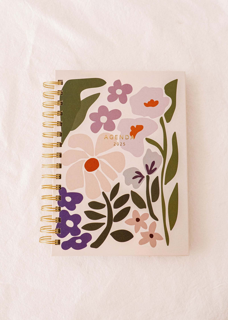 Voici le Blooming - Agenda 2025 de Mimi & August : un compagnon de planification quotidienne vibrant avec une couverture florale illustrée à la main.