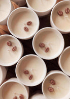 The Special Edition Candle by Mimi & August is a white jar candle, uniquely scented and topped with one or two coffee beans on the wax.