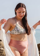 Une femme portant un haut de bikini Chichi Herboria Bralette sur la plage de Miami.