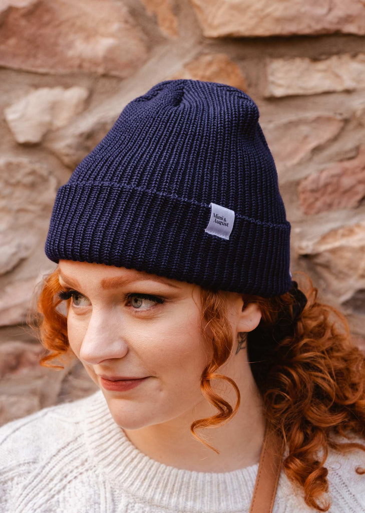 A woman wearing a Deep Blue Cuffed Beanie by mimi and august