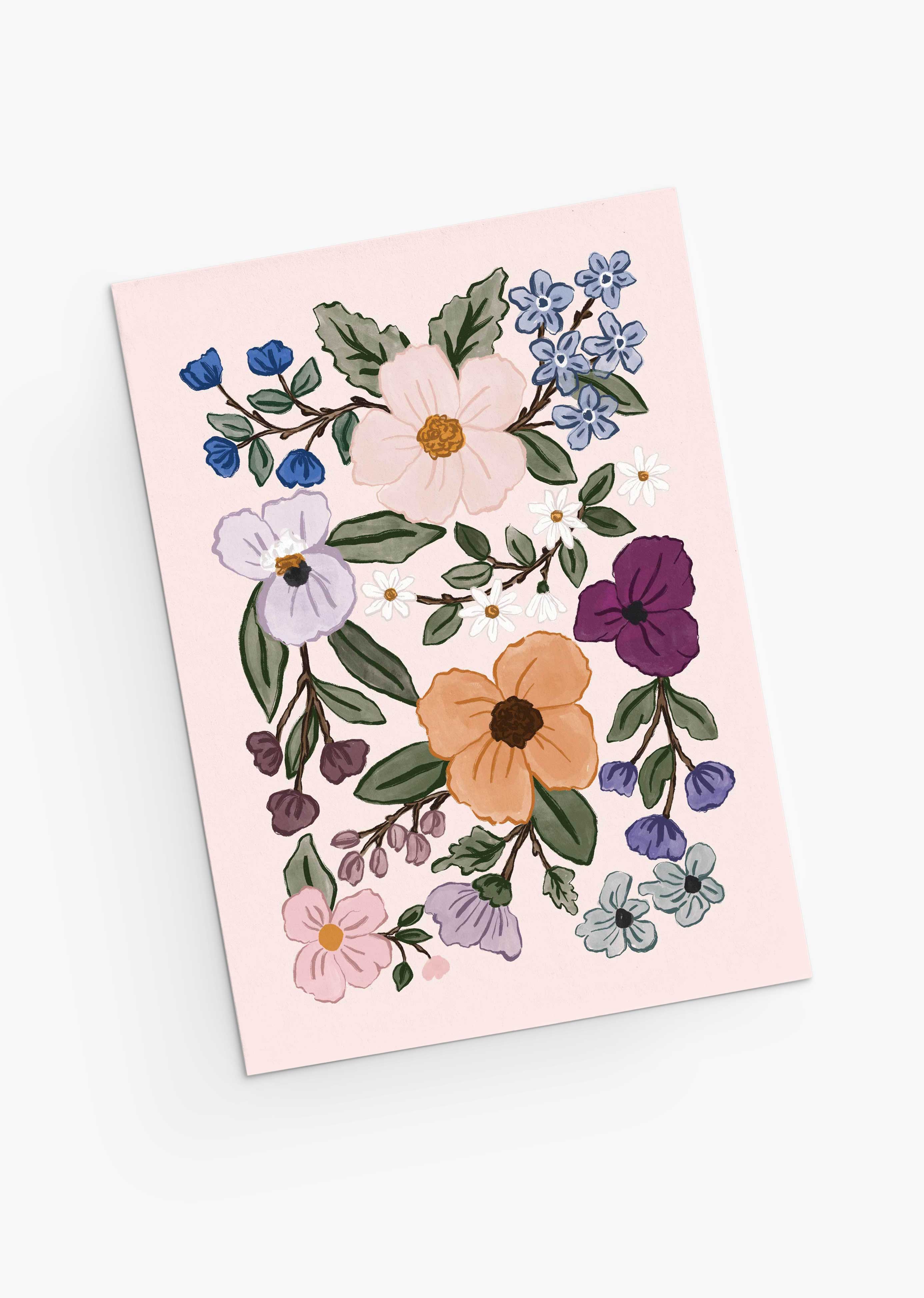 The Field of Flowers Greeting Card by Mimi & August is a pink recycled paper card featuring colorful flowers and green leaves decoratively illustrated on the front.