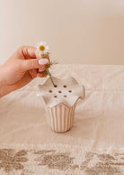 Handmade ceramic flower frog with scalloped edge on glass jar holding wildflower stems