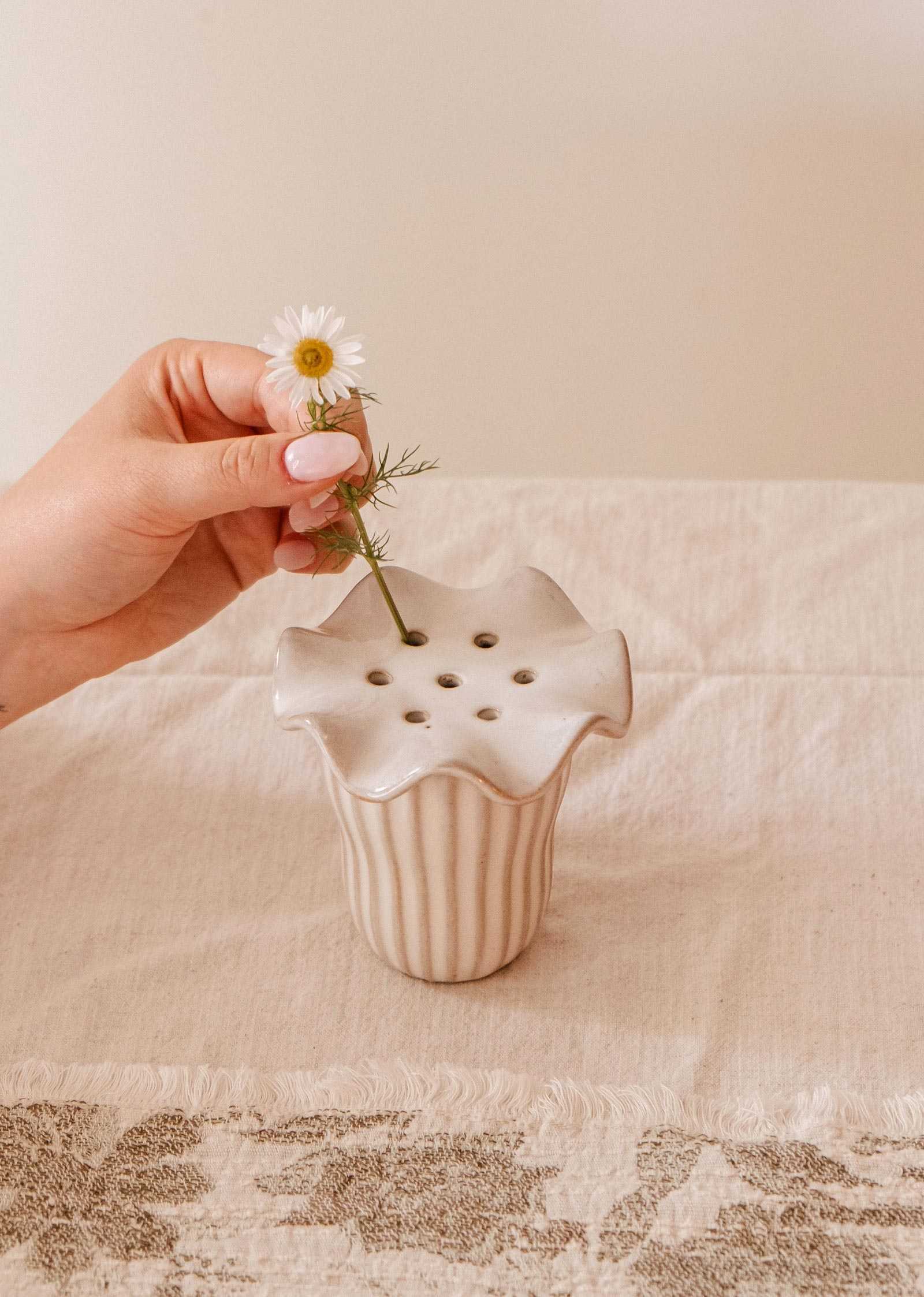 Handmade ceramic flower frog with scalloped edge on glass jar holding wildflower stems