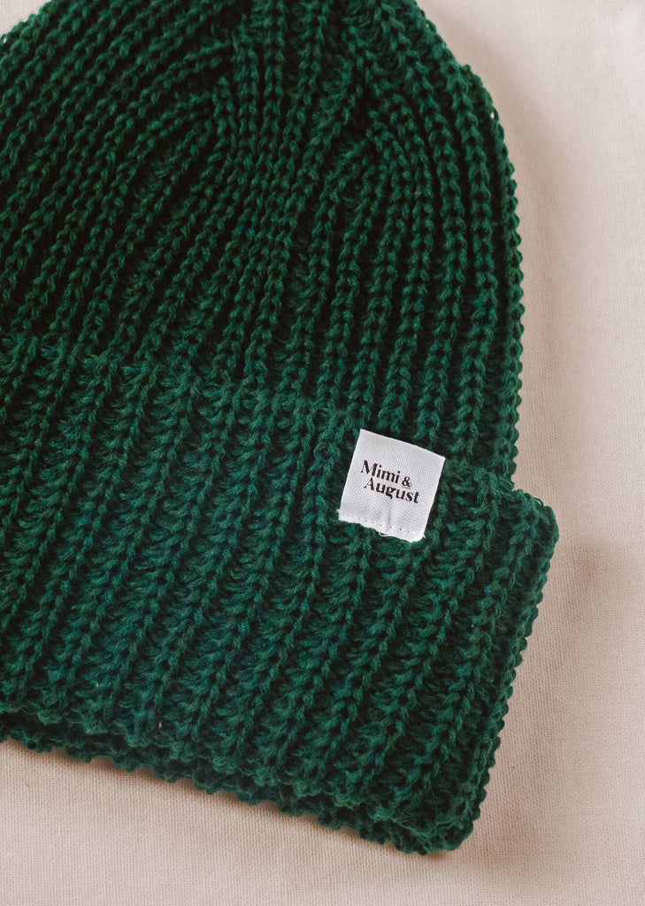 Close-up of the vibrant Forest Green Chunky Beanie by mimi and august displaying intricate knit patterns.