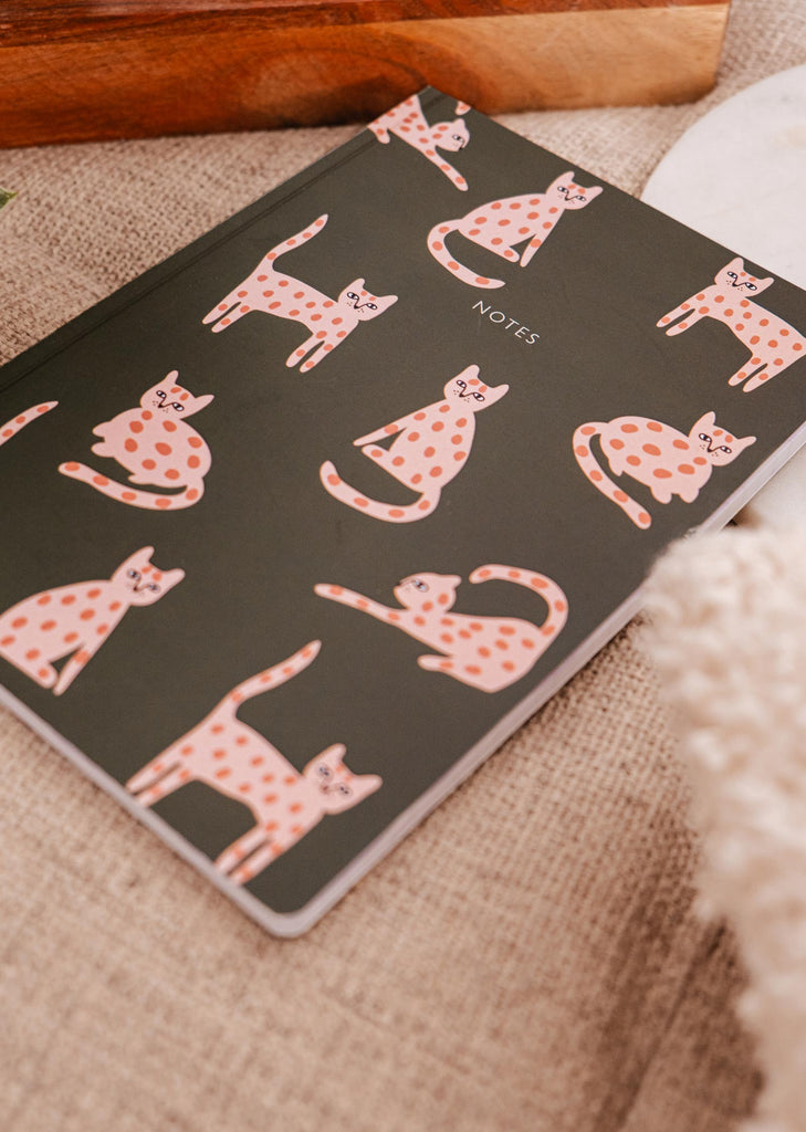 A black Leo the cat - Notebook featuring pink cats, perfect for cat lovers or fans of Leo the cat. Produced by Mimi & August.
