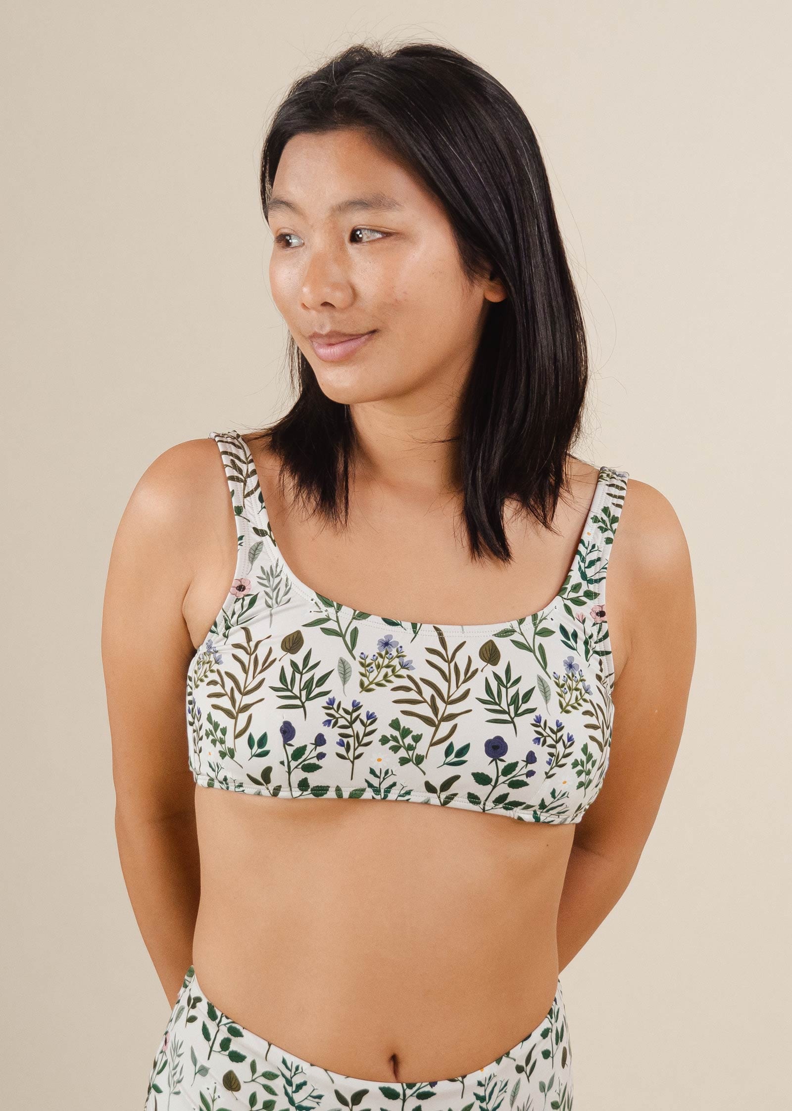 Une femme dans un haut de bikini Lima Herboria Bralette de mimi et august avec un imprimé floral.