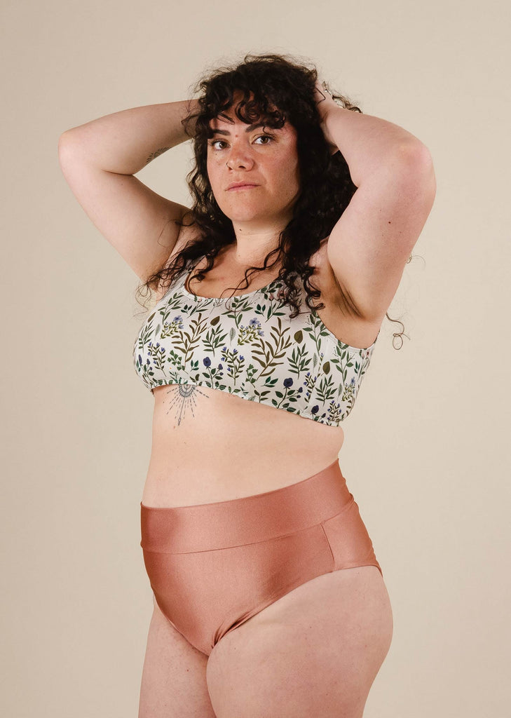 Une femme portant un haut de bikini à bralette florale et un bikini à taille haute.