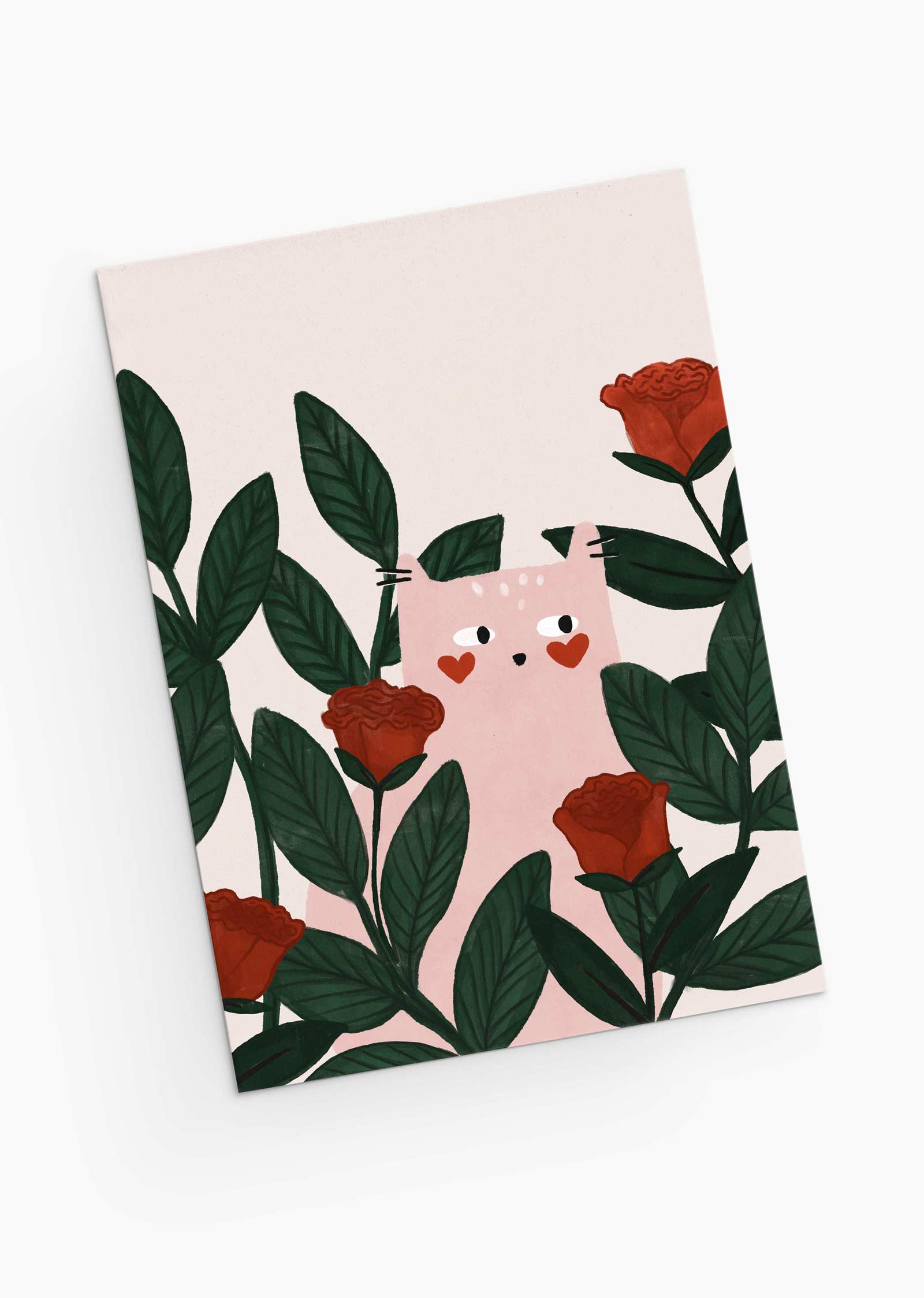 La carte de vœux Chat Lovey Dovey de Mimi & August représente un chat aux joues en forme de cœur parmi des feuilles vertes et des roses rouges, idéal pour un vœu de Saint-Valentin sur un fond blanc impeccable.