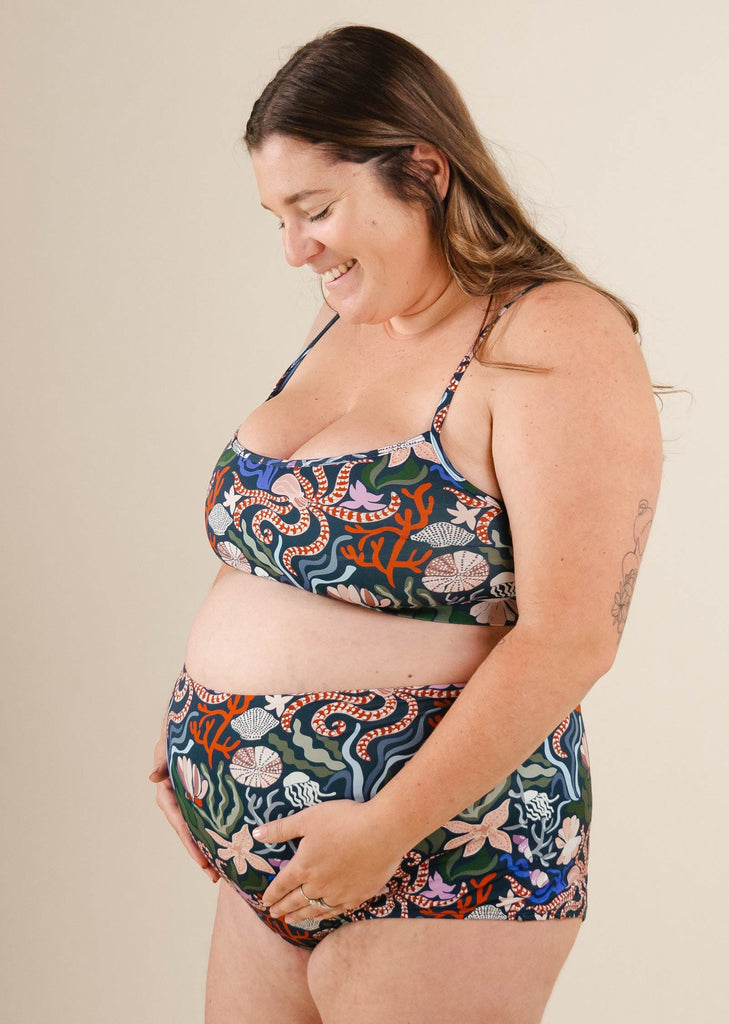 A pregnant woman in a Mango Oceana Bralette Bikini Top.