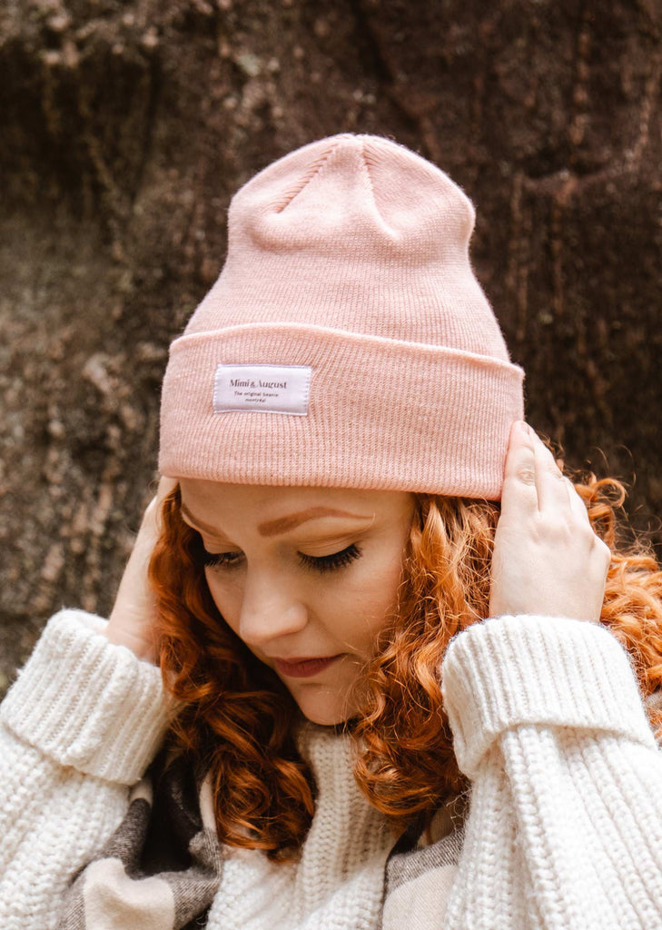  A woman wearing a mimi and august Pale Rose Beanie.