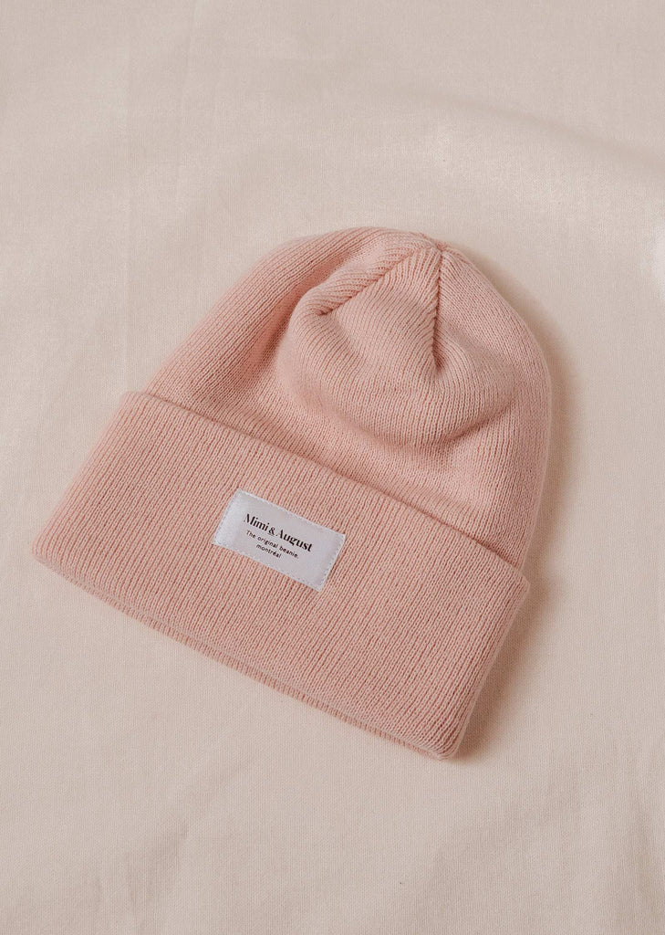 A Pale Rose Beanie with a mimi and august label on it.