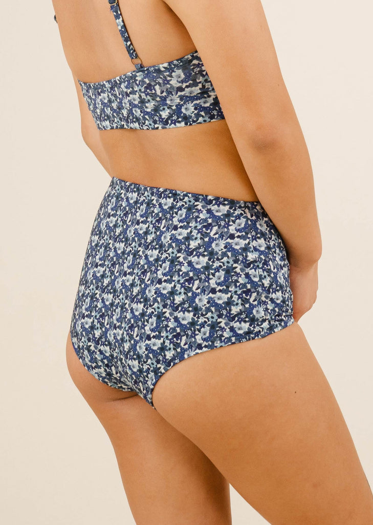 a woman in a blue floral print bikini bottom by mimi and august