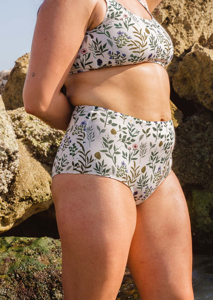 Une femme en bas de bikini taille haute Paloma Herboria par mimi et august profitant de la journée ensoleillée sur la plage de Miami.
