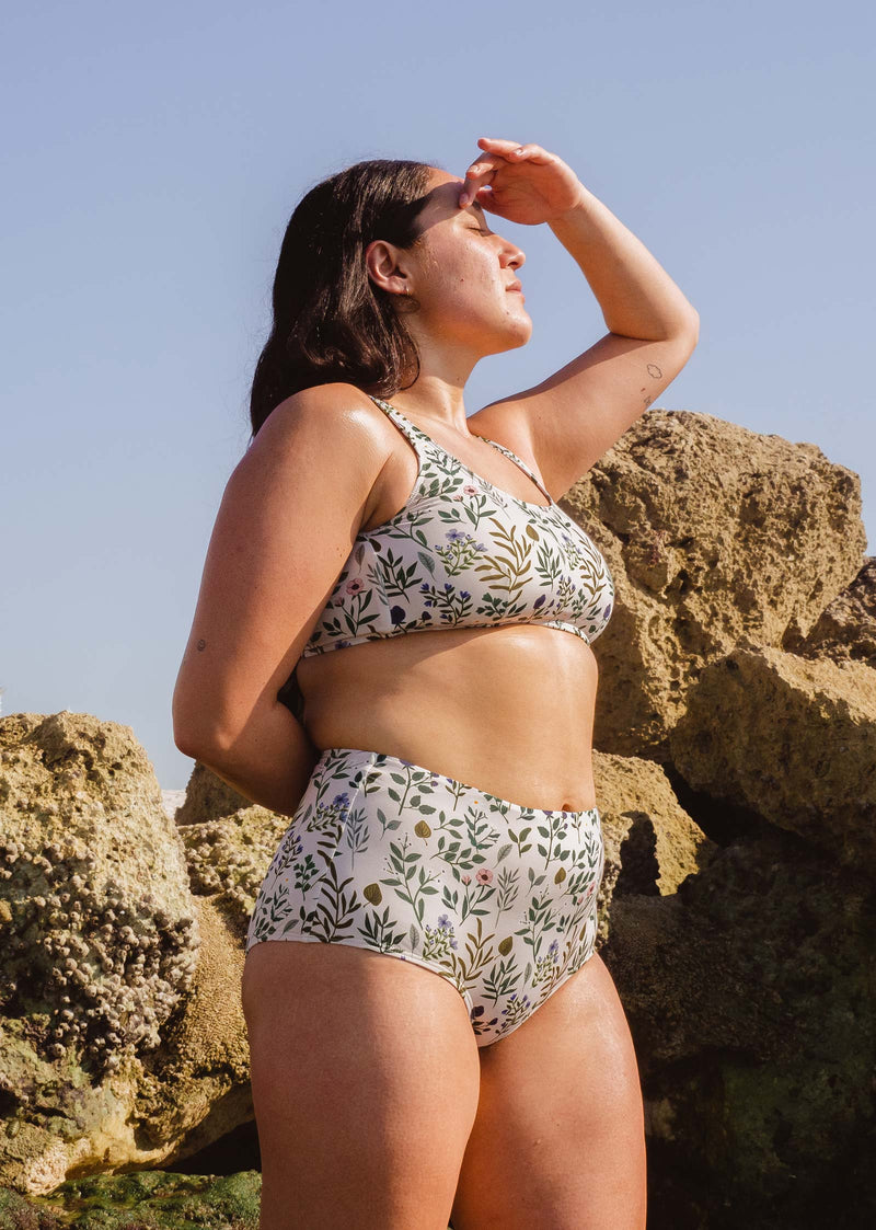 Une femme à la plage portant un bas de bikini taille haute Paloma Herboria de mimi et august.