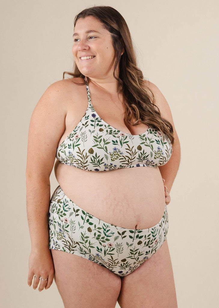 Une femme enceinte dans un bas de bikini fleuri taille haute mimi et august.