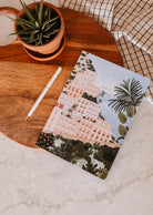 A Mimi & August Positano notebook on a wooden table.