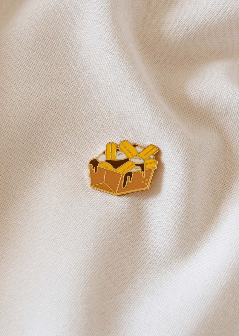 	A poutine enamel pin inspired by Quebec culture