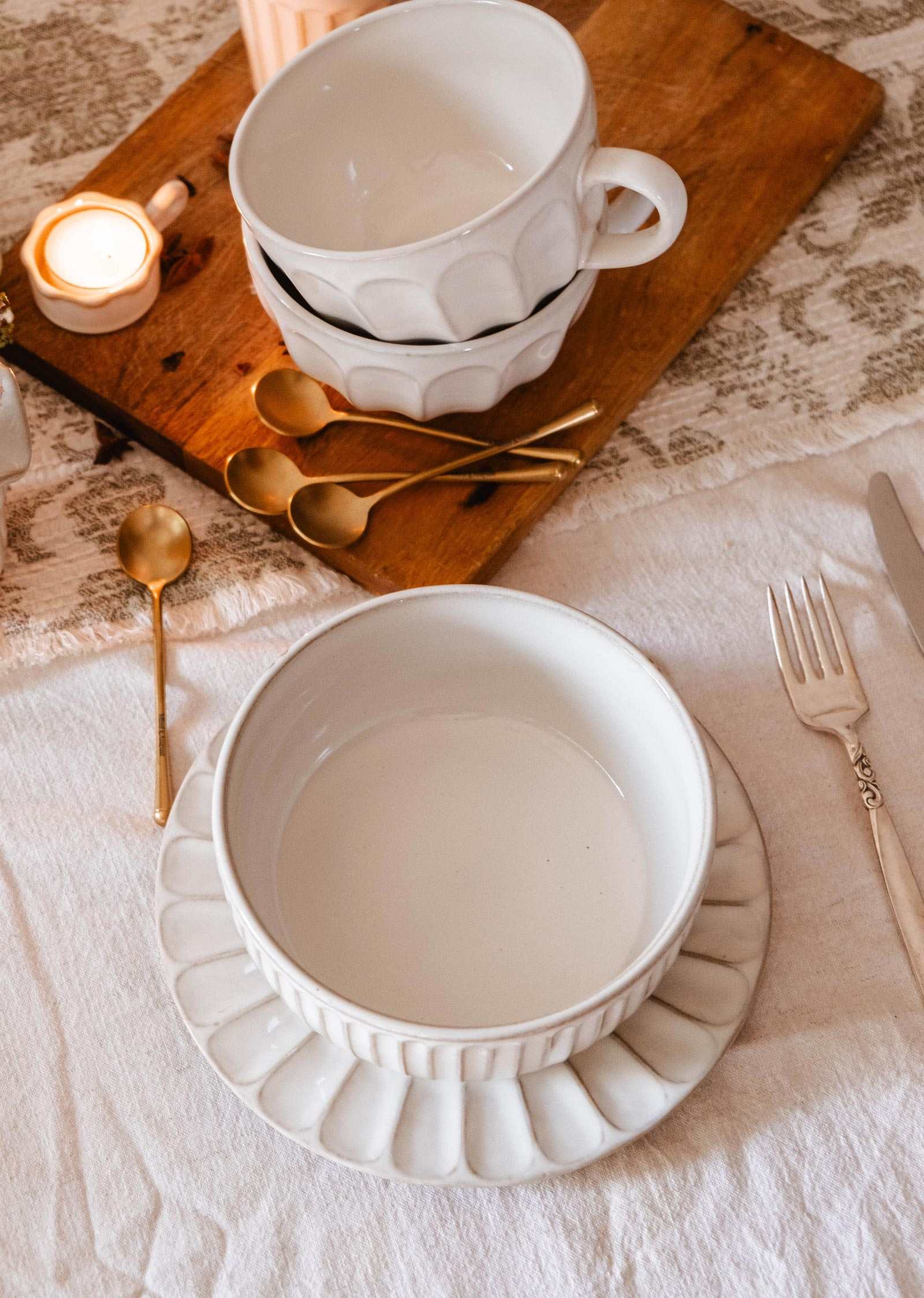 Handmade ceramic bowl with cream glaze and ribbed texture on table
