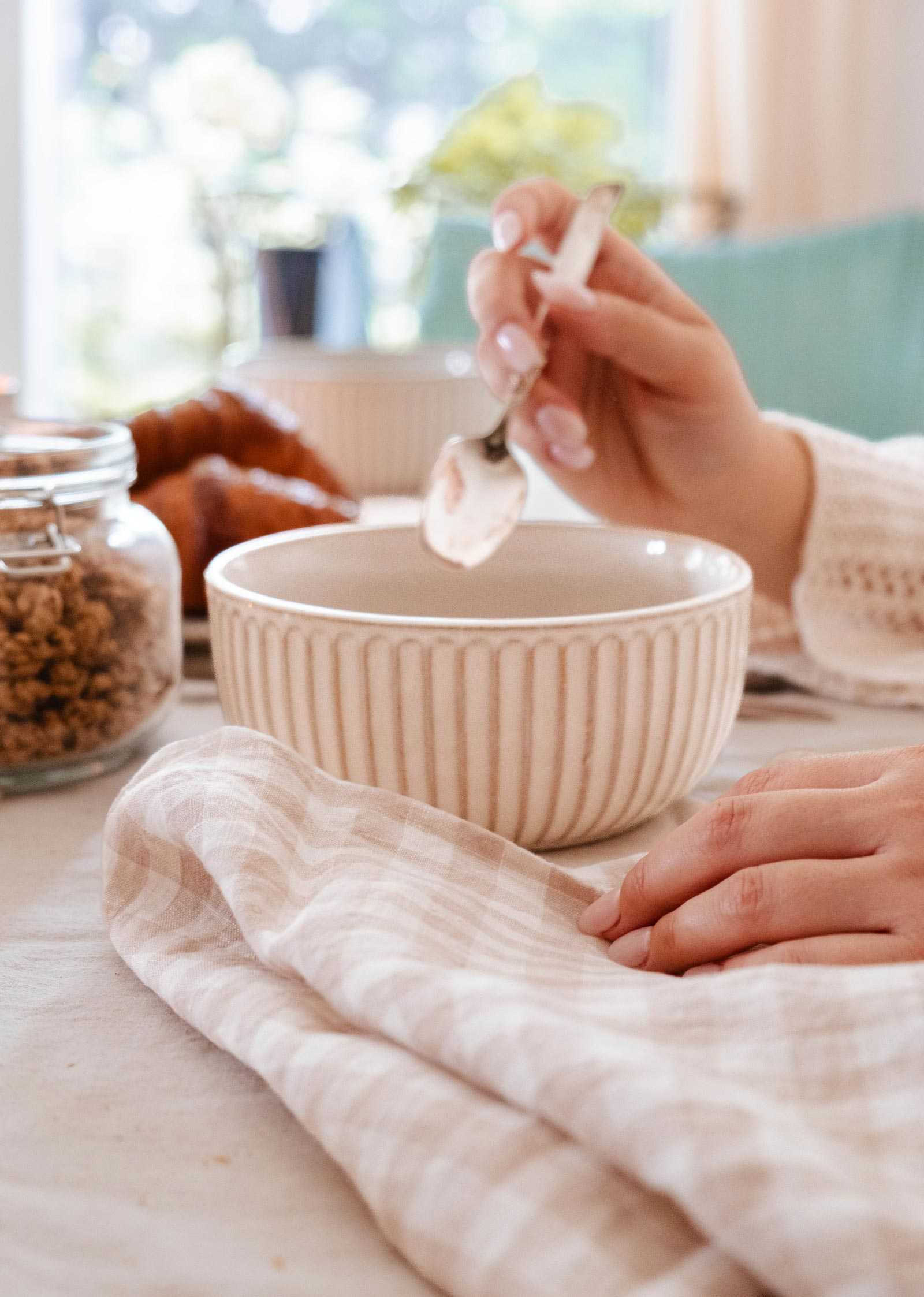 Handmade ceramic bowl with ribbed detailing on wooden table