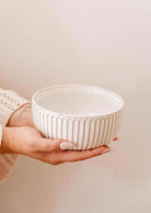 Handmade ceramic bowl by Mimi & August held in hands, showing ribbed texture