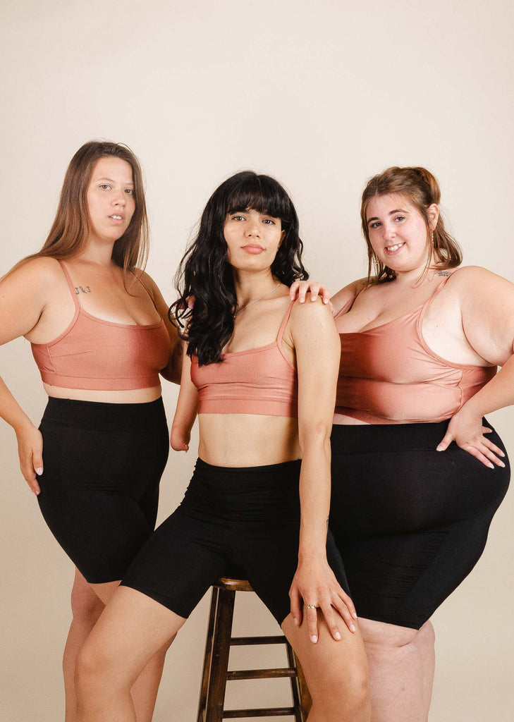 	Three women posing for a photo in black Riviera swim biker shorts from the brand mimi and august.