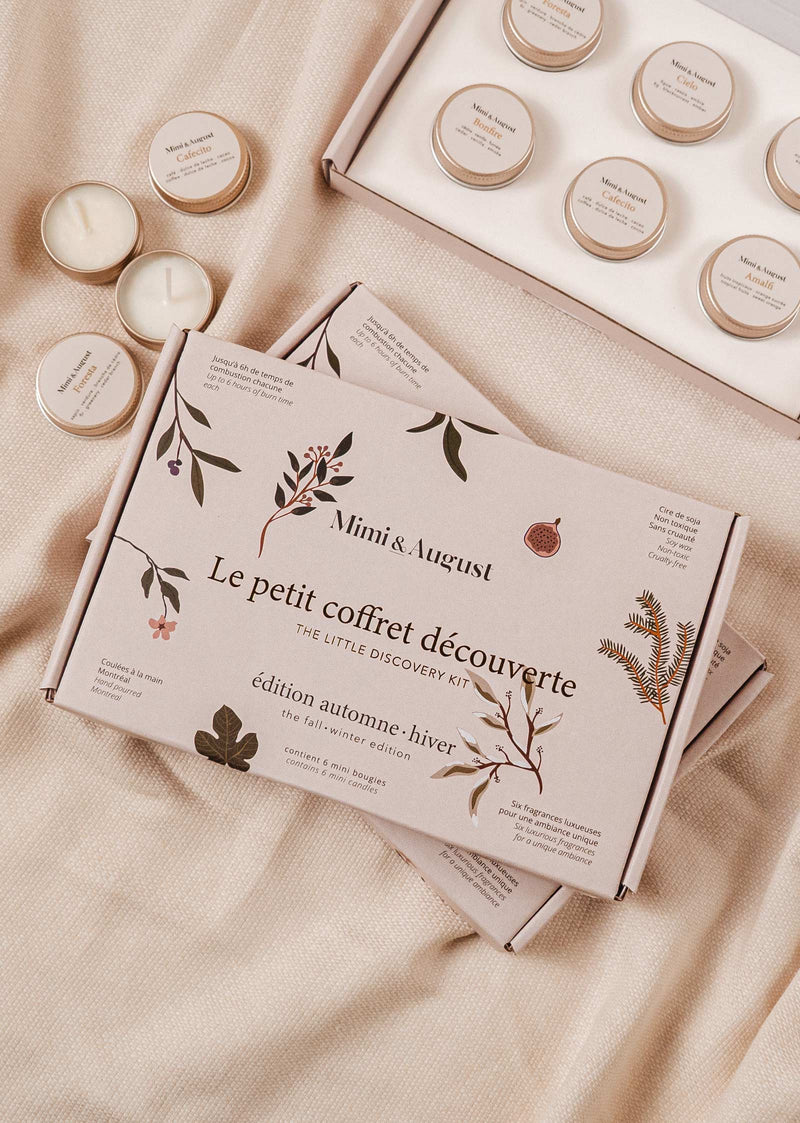 The "Mimi & August Fall/Winter Discovery Kit" with scents for fall/winter, placed on a bed.
