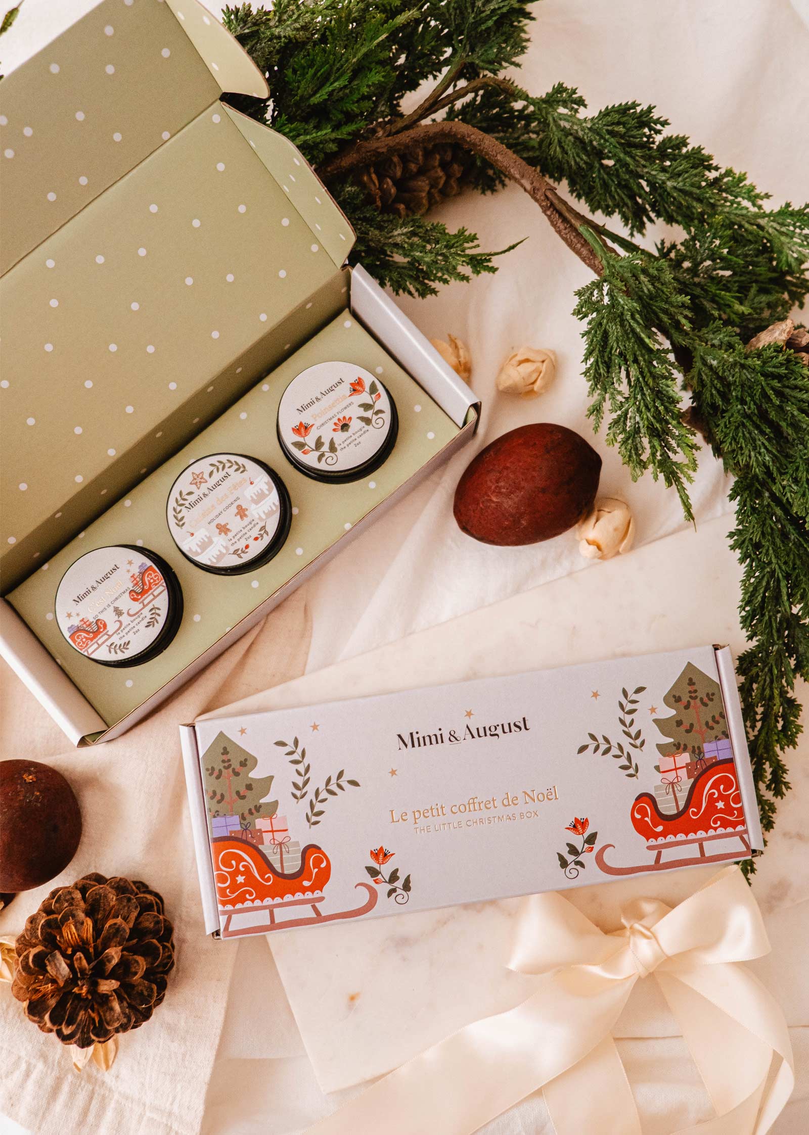 La Petite Boîte de Noël de Mimi & August est un charmant coffret contenant trois petits pots élégamment présentés dans un emballage de fête. Sur fond de tissu blanc et ornée de pommes de pin, de brindilles et de noix, cette collection incarne des fragrances inspirées des fêtes, idéales pour toute atmosphère de célébration.