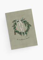The Best Season Christmas Greeting Card by Mimi & August features an illustrated wreath with a white bow and red berries, “la meilleure saison” text on muted green, is blank inside for your message, and printed on recycled paper.
