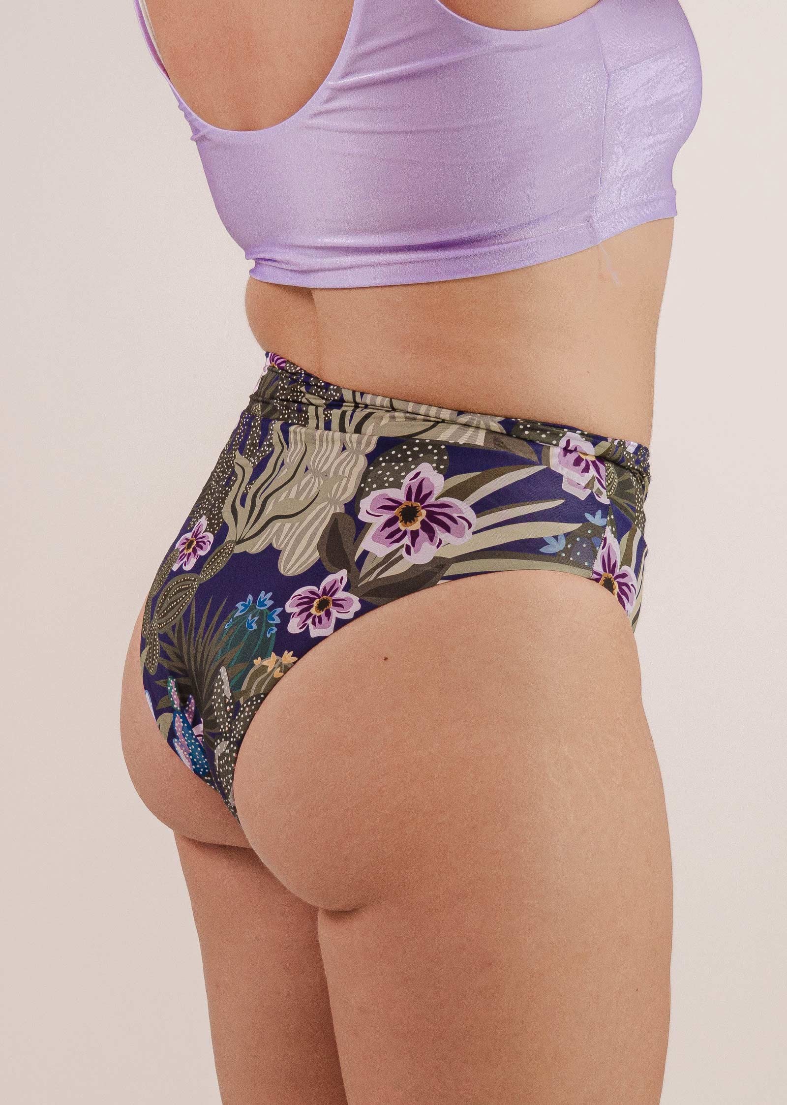 Person wearing a light purple top and Mimi & August Tofino Jardin de Nuit High Waist Bikini Bottom, photographed from behind.